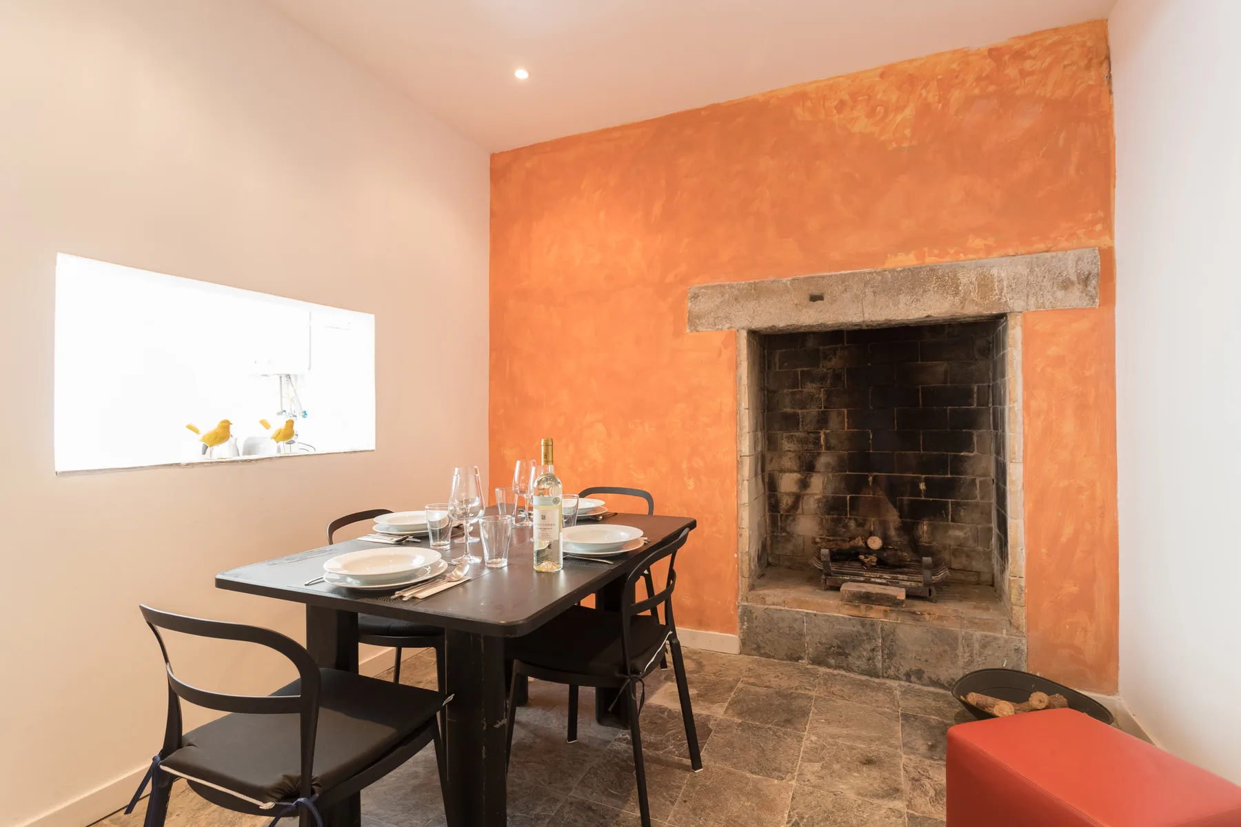Comedor con una mesa y asientos junto a una chimenea.