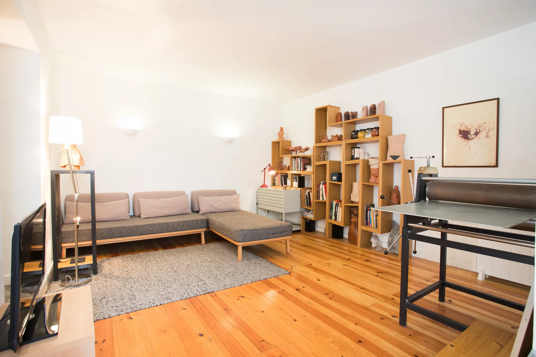 Una sala luminosa con asientos, estanterías y suelo de madera.