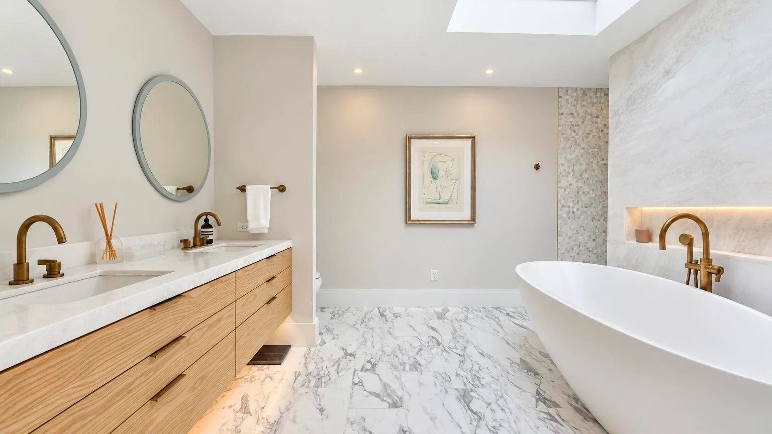 A bright bathroom features a freestanding tub and a long vanity.