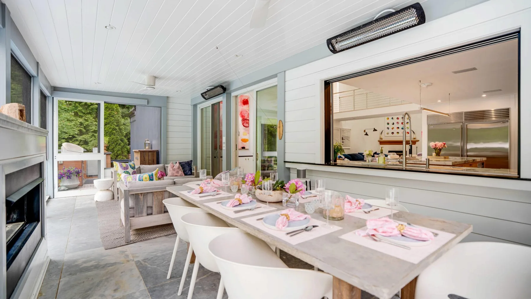 A bright dining area with a long table set with dishes and flowers.