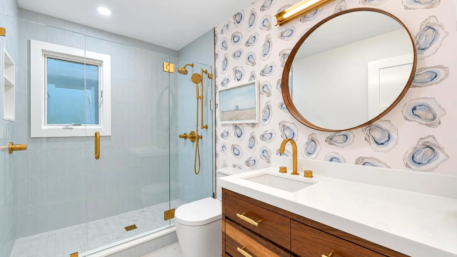 A bright bathroom with a glass shower, toilet, and wooden vanity.