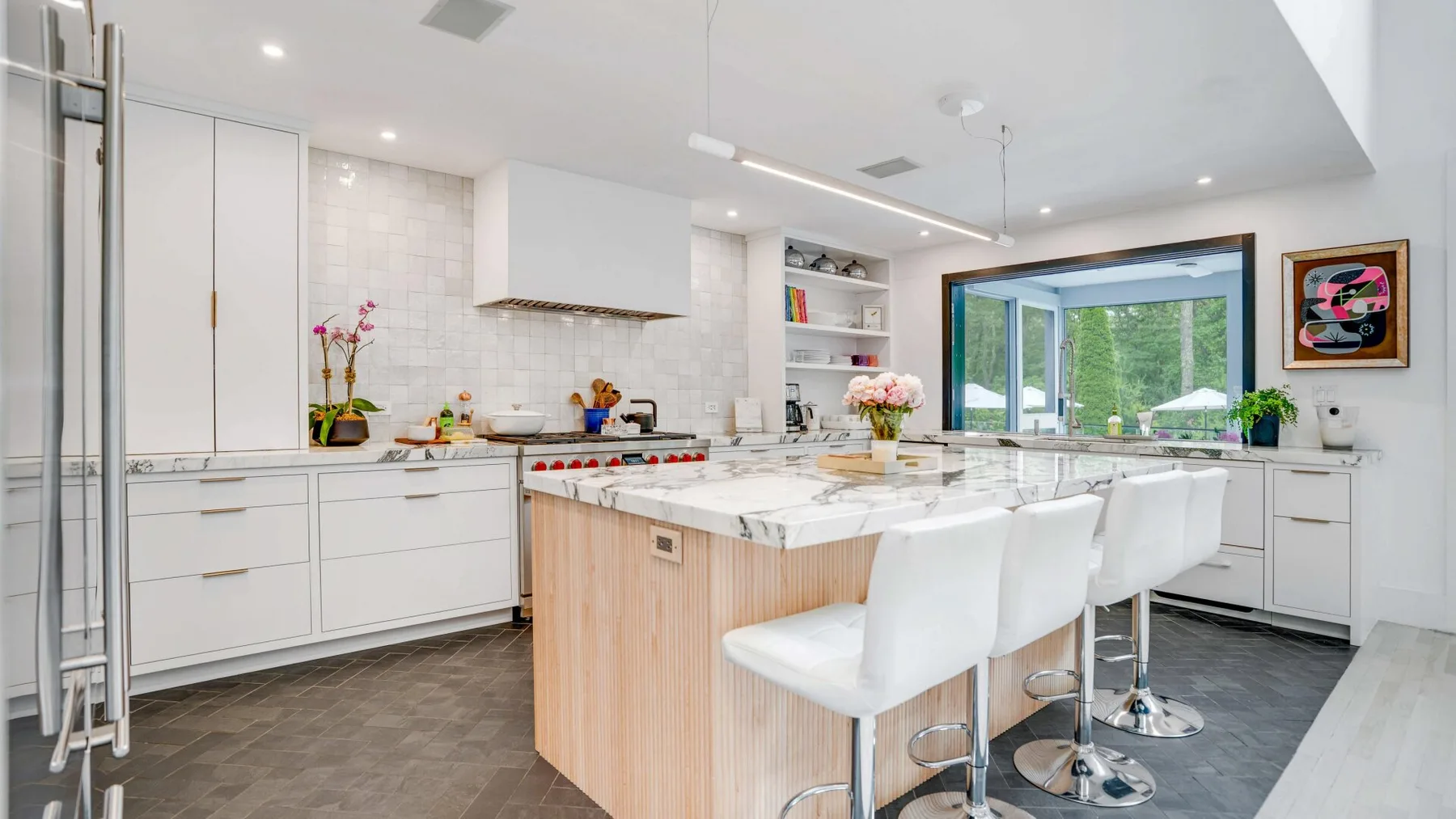 A bright modern kitchen with a large island and white seating.