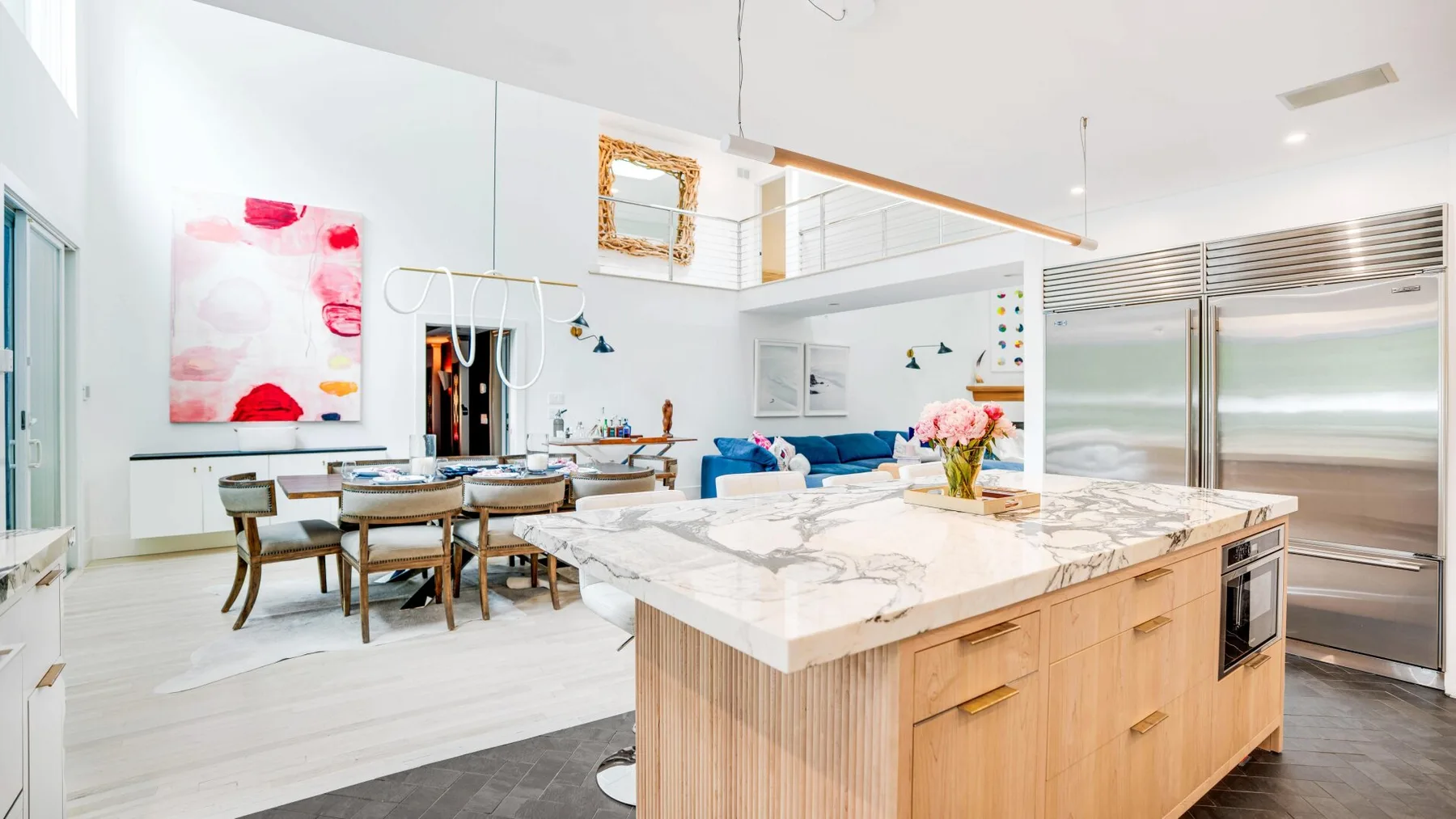 A bright open-plan kitchen and dining area with a large island and dining table.