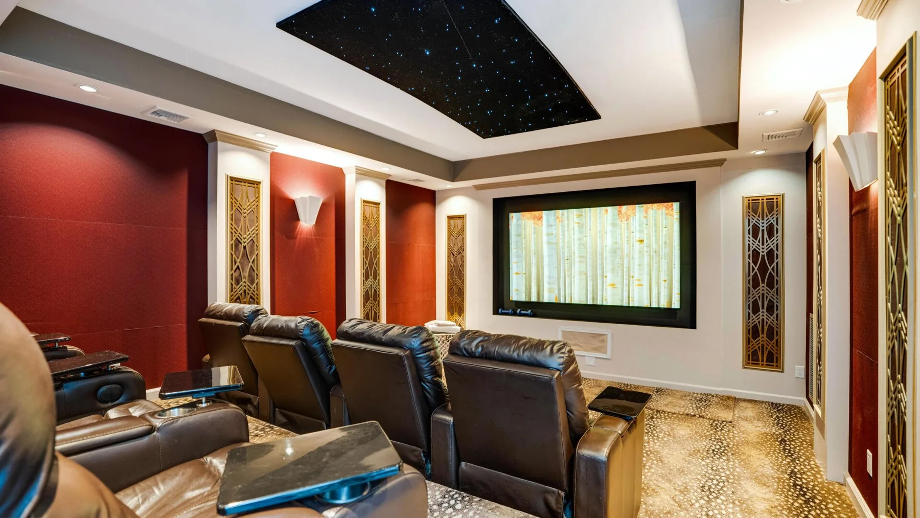 A home theater with rows of reclining seats facing a screen.