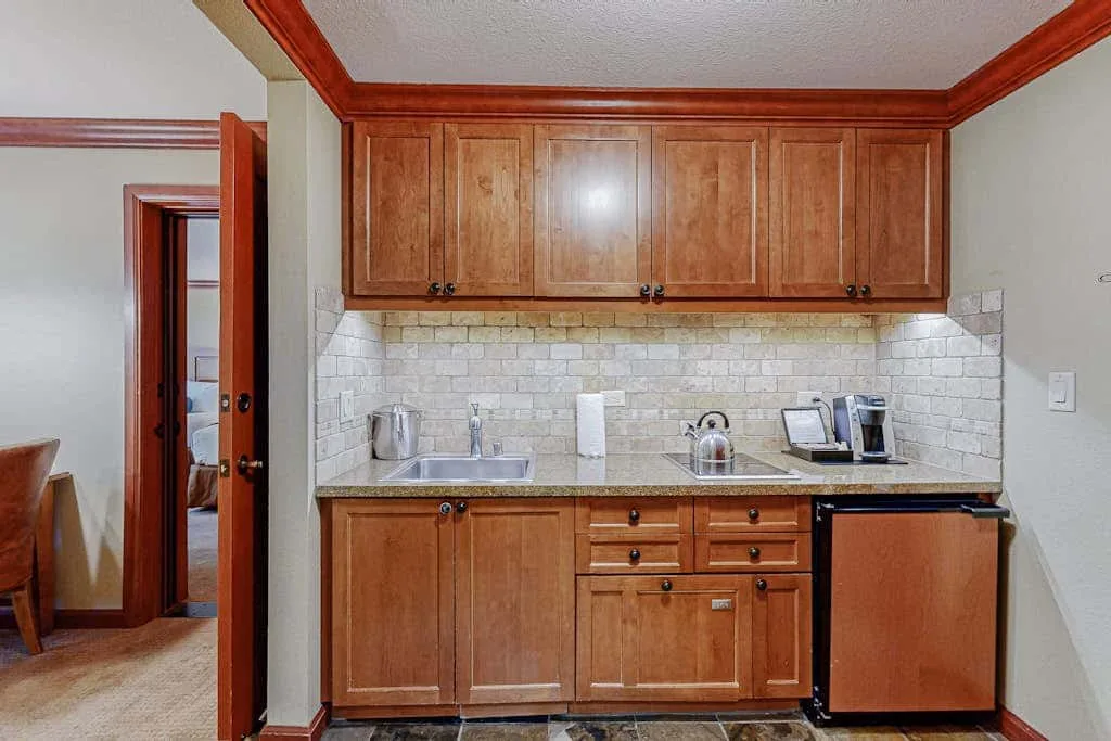 Una pequeña zona de cocina con armarios de madera, un fregadero y una encimera.