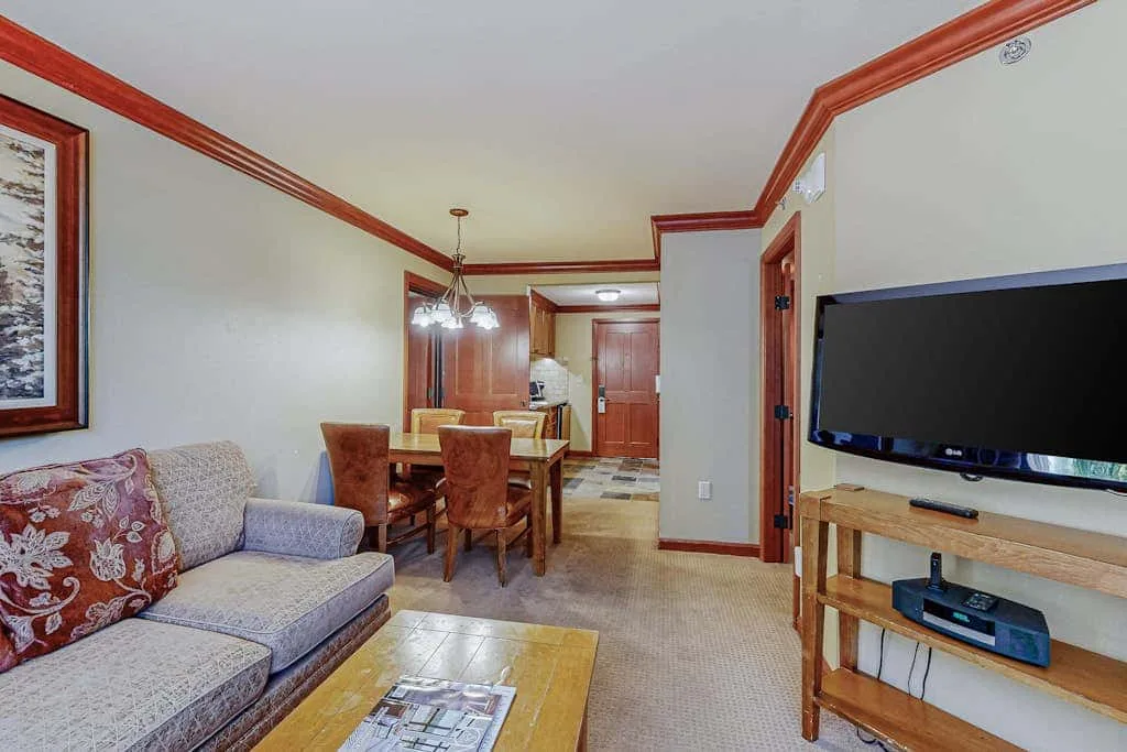 Una sala de estar con asientos, una mesa de comedor y un televisor.