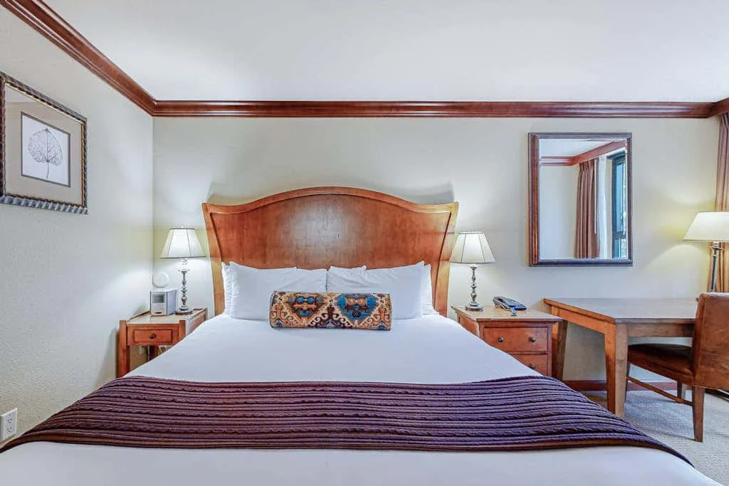 Un dormitorio con una cama bien tendida y mesitas de noche a juego.