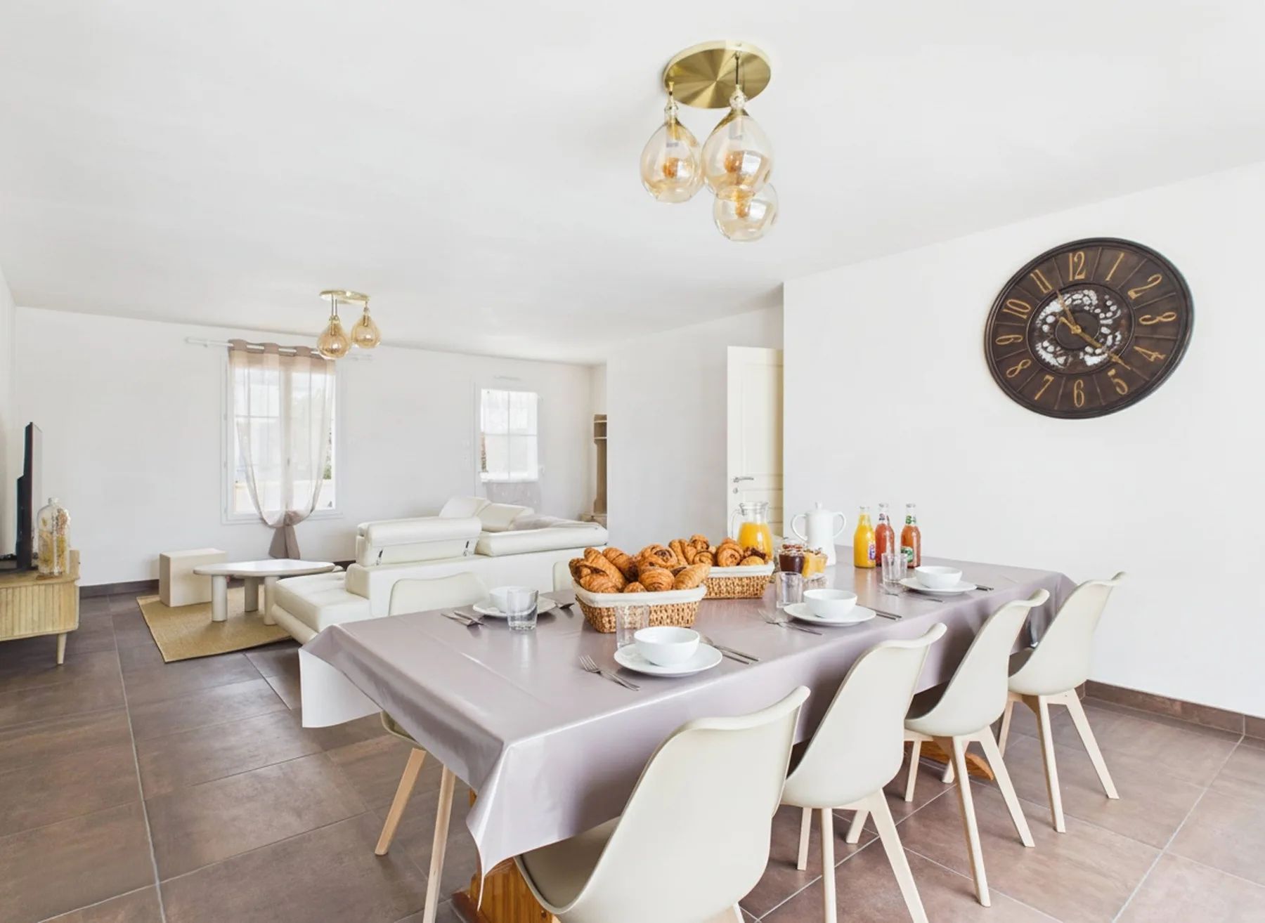 A dining table with chairs sits in an open living and dining room.