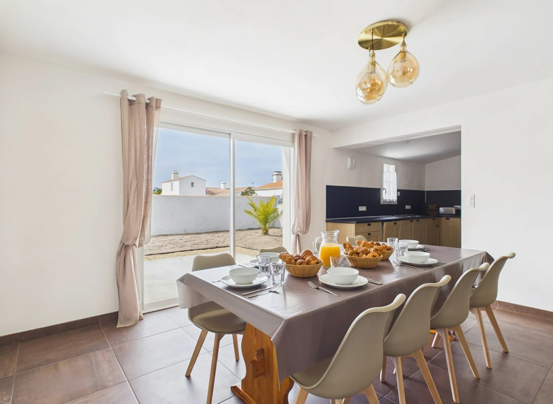 Dining area with a set table beside a large window.