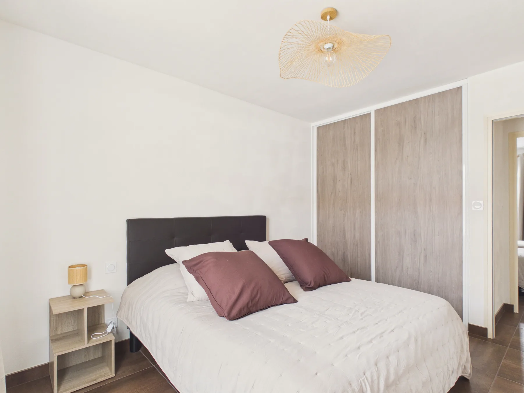 A bright bedroom with a bed and a ceiling light.