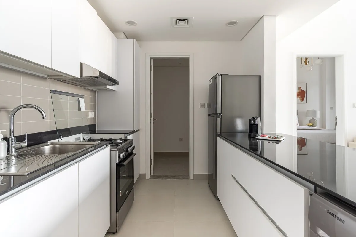 Una cocina moderna con gabinetes blancos, un fregadero y una isla central.