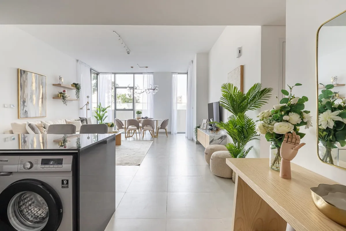Una luminosa sala de estar y comedor de concepto abierto, con ventanales y plantas de interior.