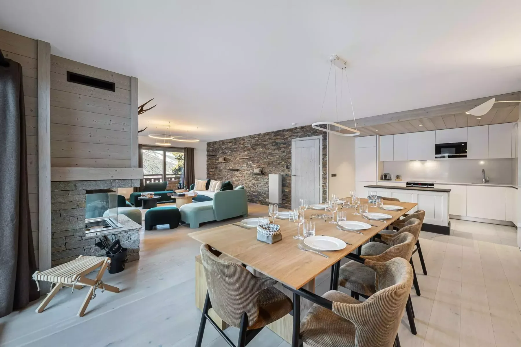 Un espacio abierto de comedor y sala de estar con una mesa larga y una cocina moderna.