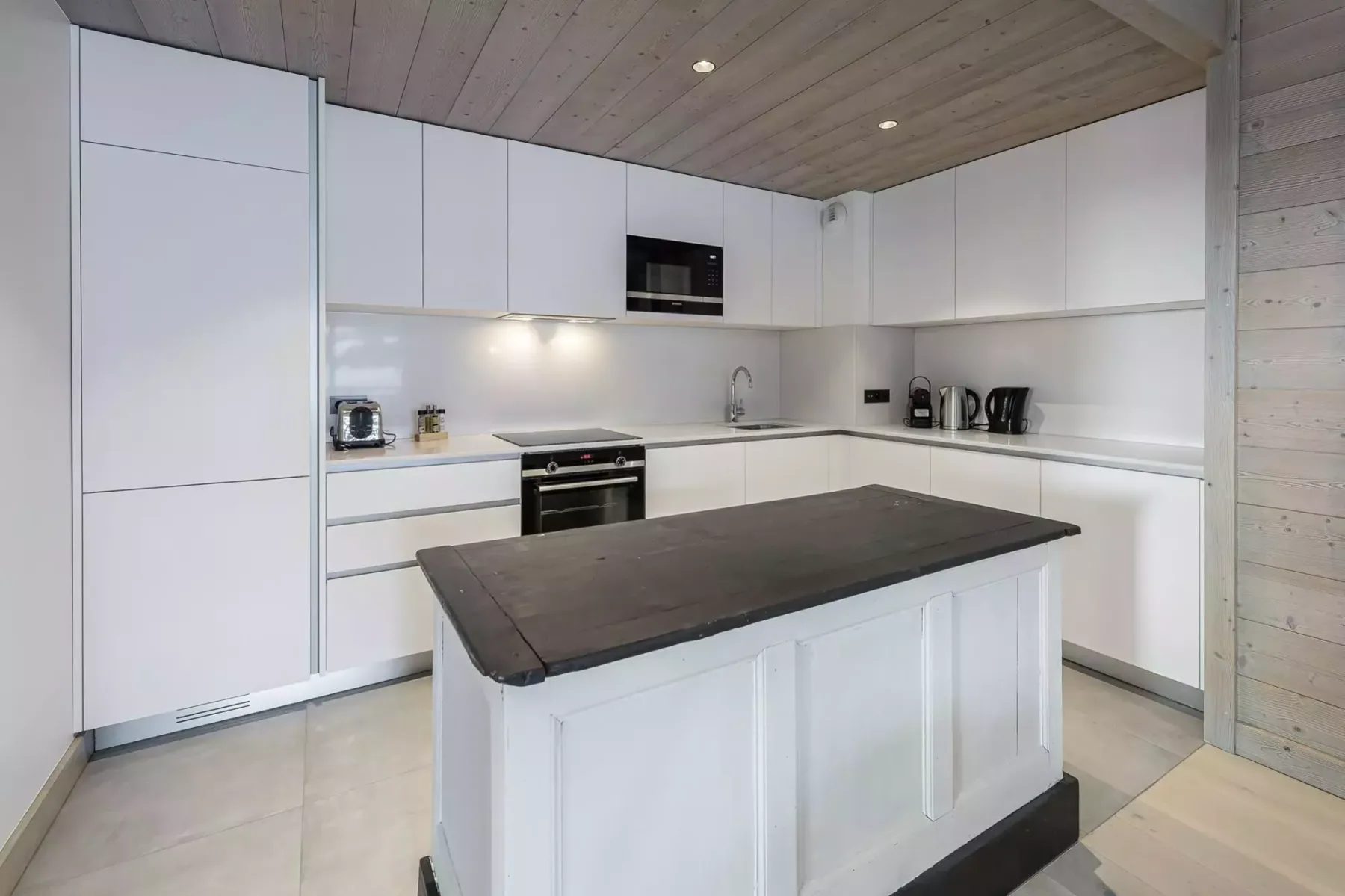 Una cocina moderna con gabinetes blancos y una isla central grande.