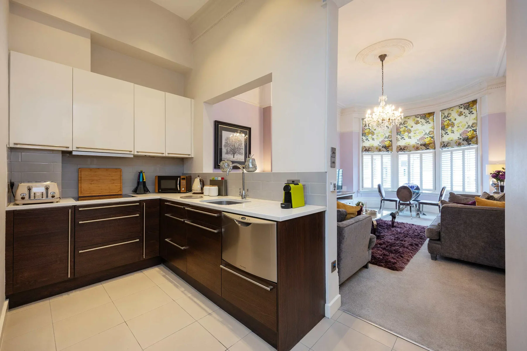 Cocina y sala de estar de concepto abierto, con una mesa junto a las ventanas.