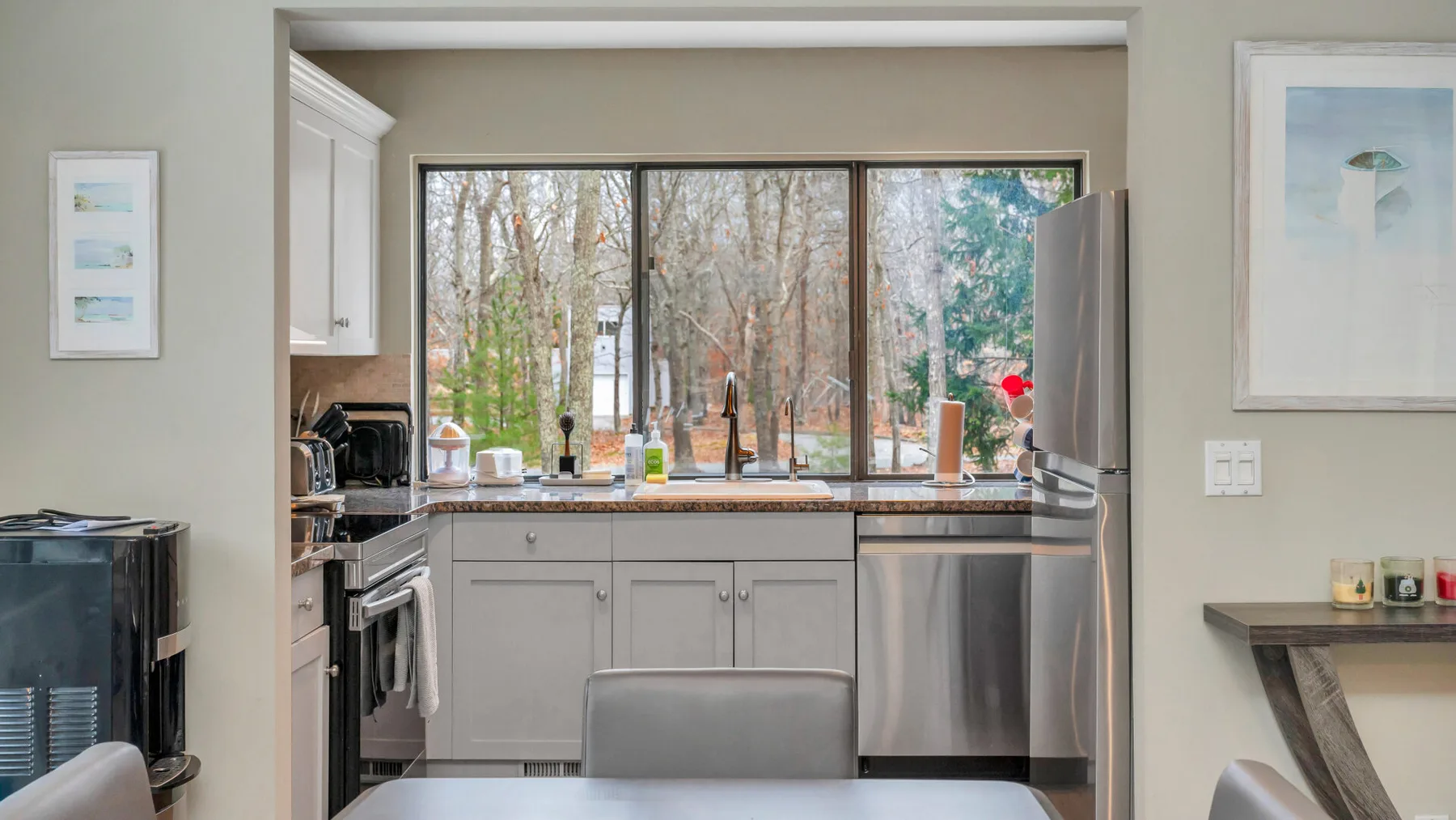 Una cocina luminosa con una amplia ventana que da a los árboles.