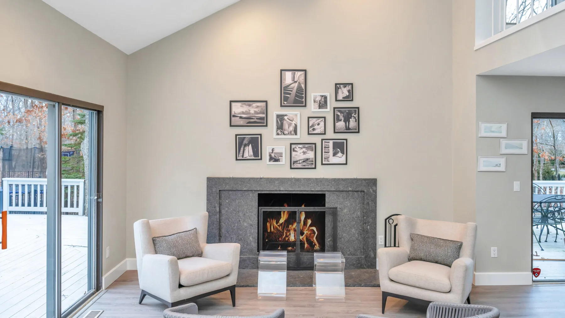 Una sala de estar con dos sillones junto a una chimenea y cuadros en la pared.