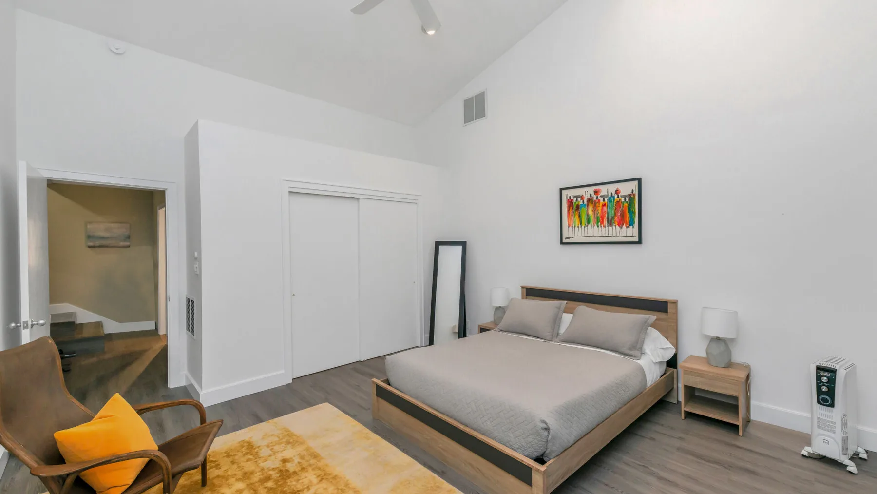 Un dormitorio con una cama, una mesa de noche y un sillón.