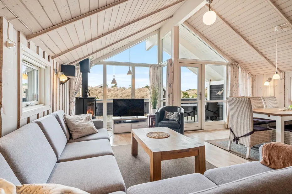 A bright living room with seating, a coffee table, and large windows.