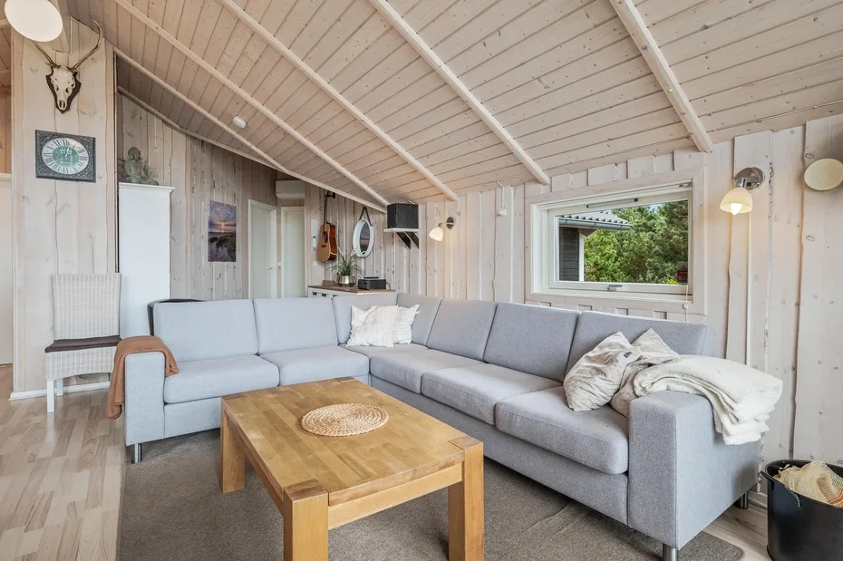 A bright living room with a large sectional sofa and a wooden coffee table.