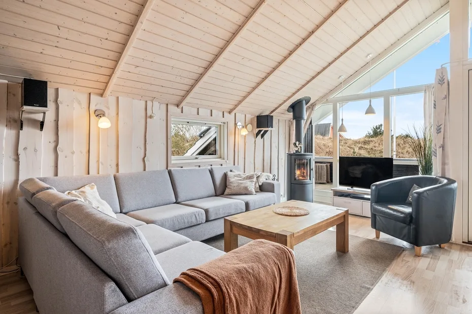 A bright living room with sectional seating, a coffee table, and large windows.