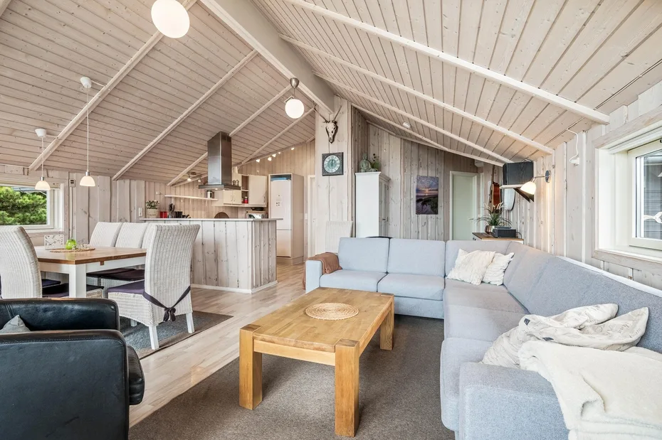 An open-plan living and dining area with light seating and a wooden coffee table.