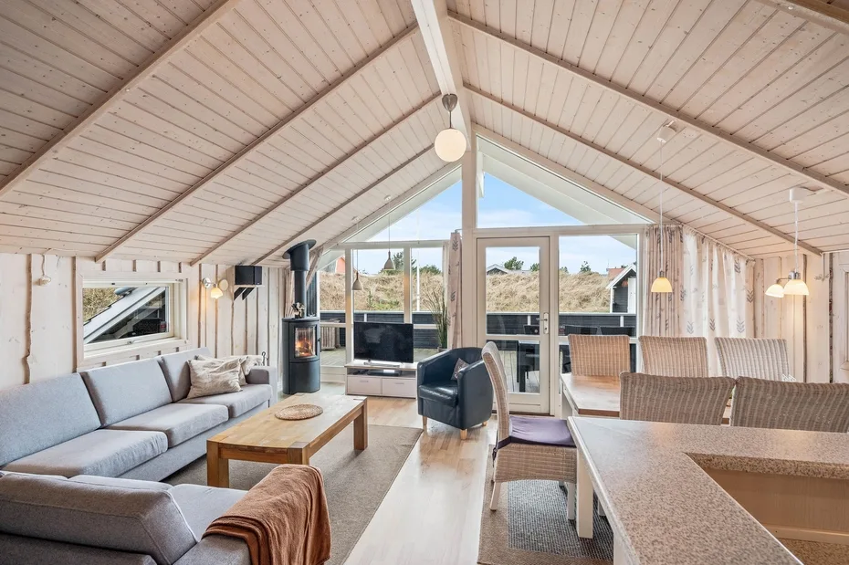 A bright open-plan living and dining area with seating and large windows.