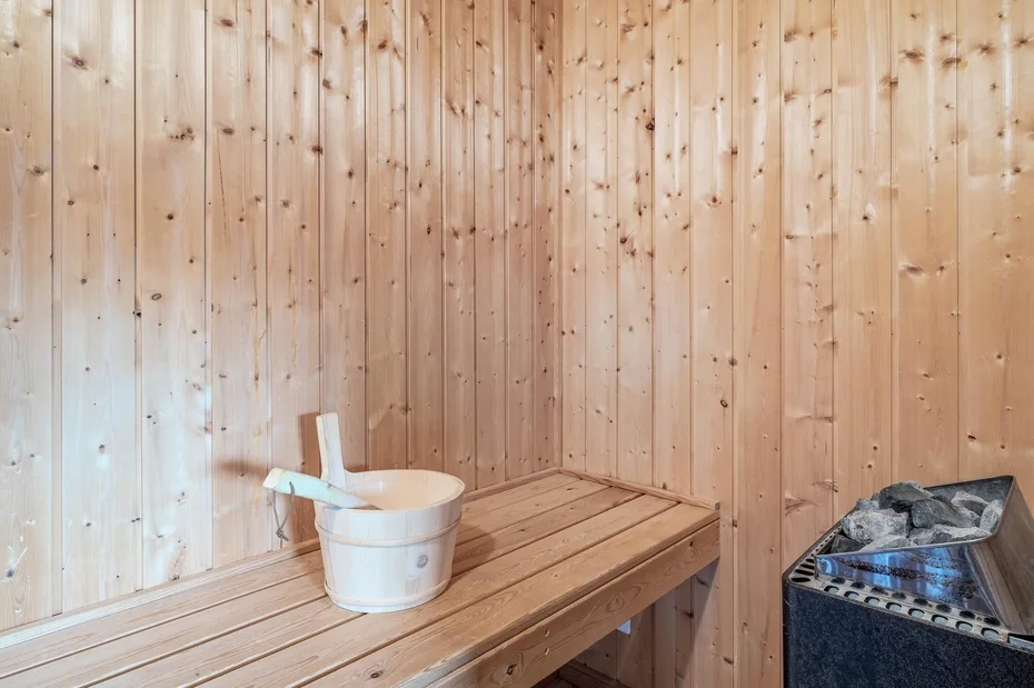 A wood-paneled sauna room with a bench and a heater.