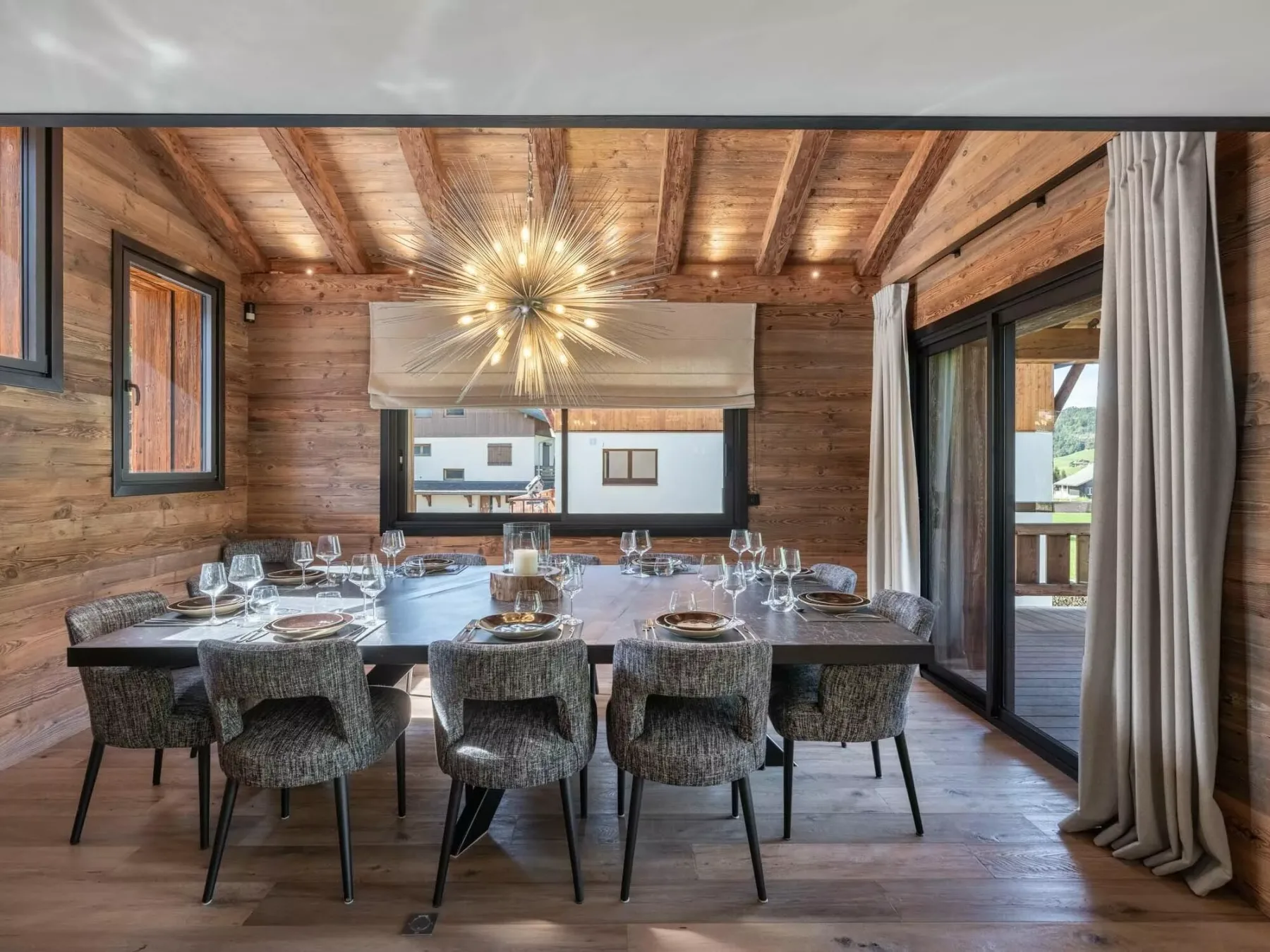 Comedor con una mesa larga puesta bajo una lámpara de rayos.