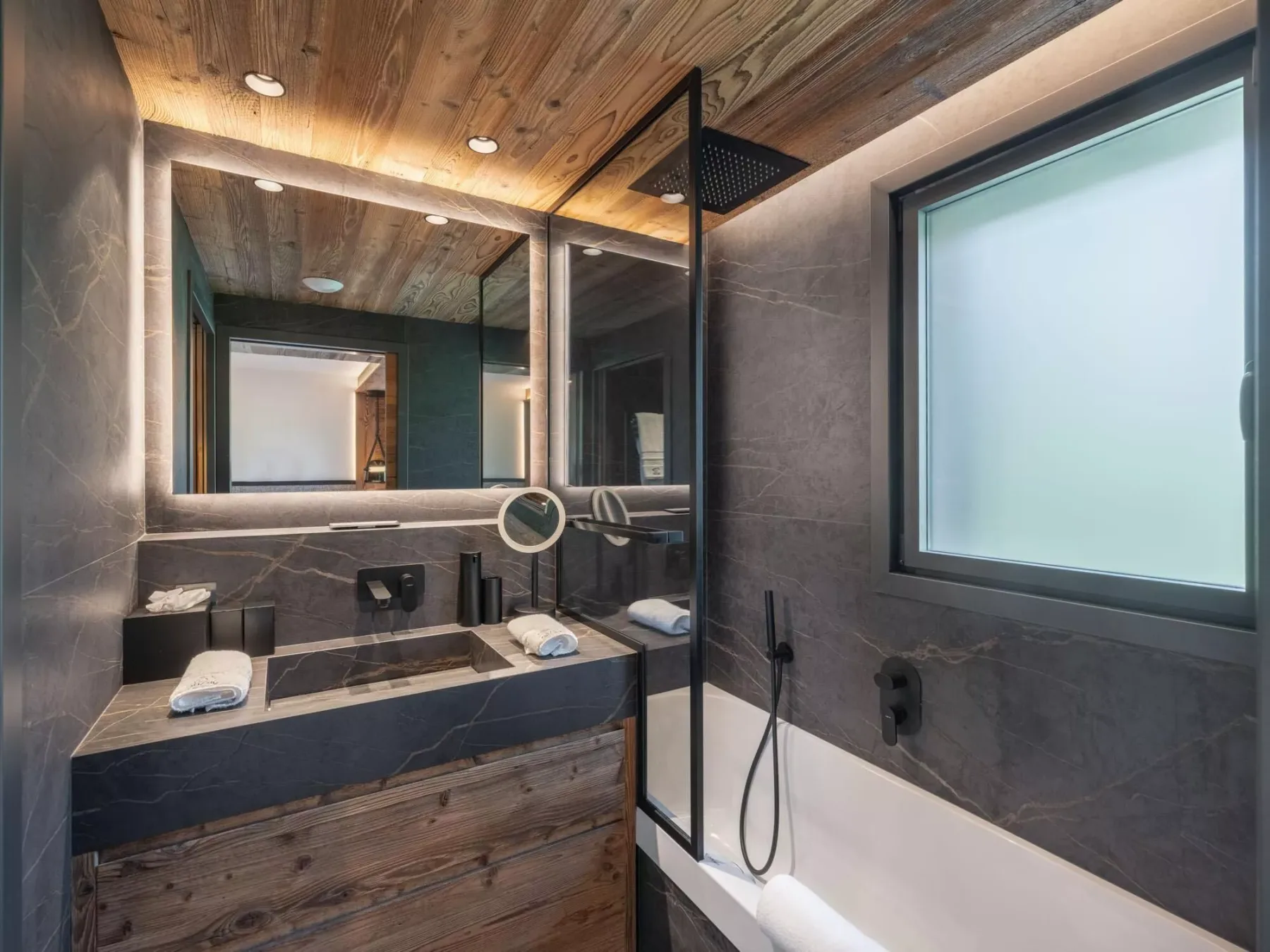 Un baño moderno con un amplio lavabo, un espejo grande y una ducha.