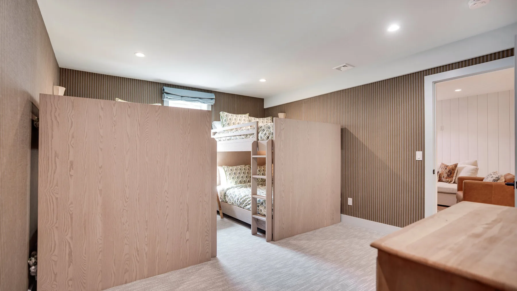 Un dormitorio con literas y tabiques de madera de media altura.