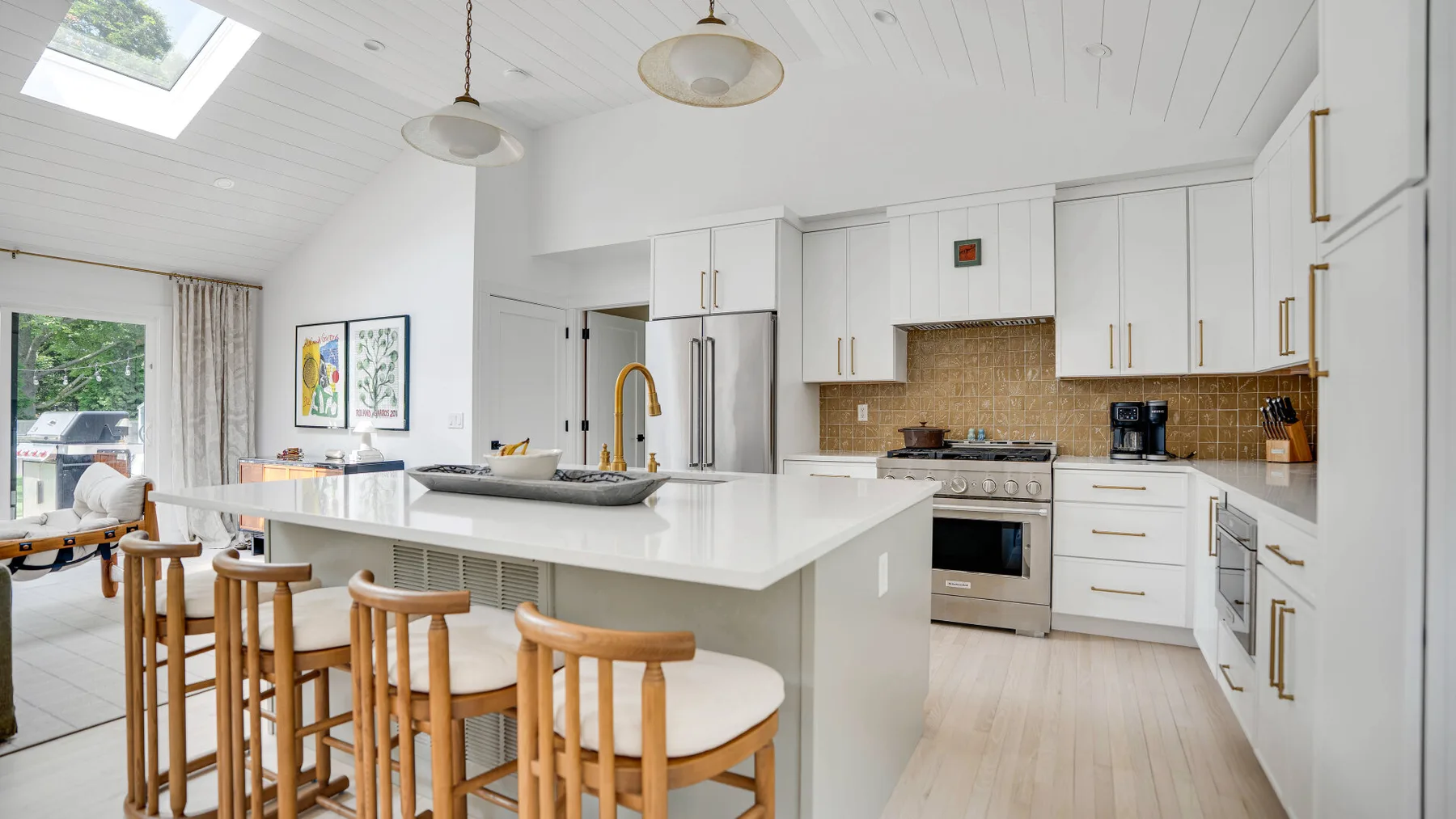 Una cocina luminosa con una isla grande y un comedor junto a las ventanas.