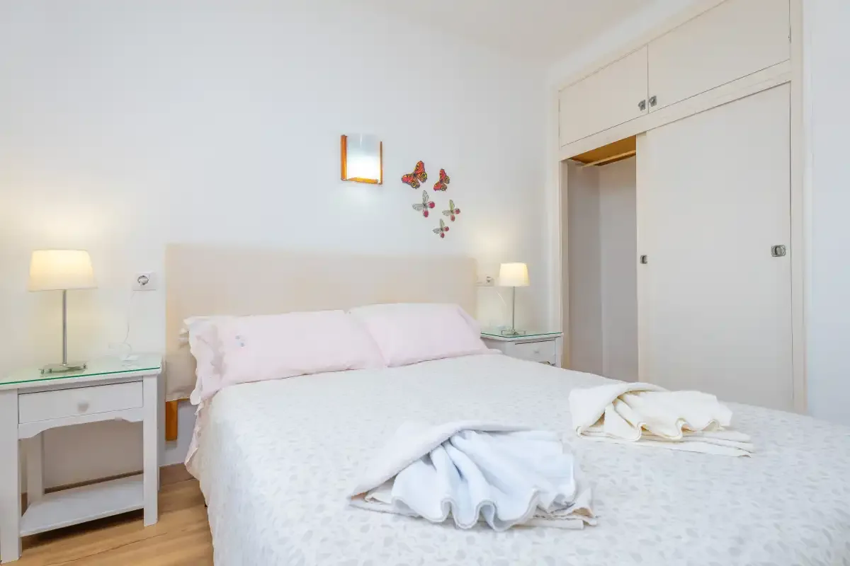 A bright bedroom with a double bed and bedside tables.
