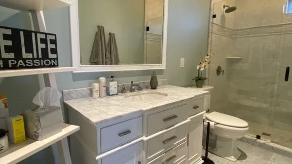 Un baño con un lavabo amplio, espejo y ducha de vidrio.