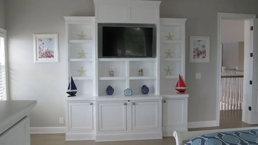 Una sala de estar con un mueble empotrado y un televisor.