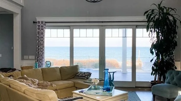 A living room with seating and glass doors opening onto a balcony.