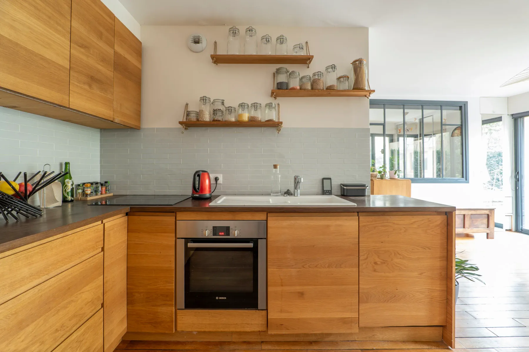 A modern kitchen with wooden cabinetry and a central island.