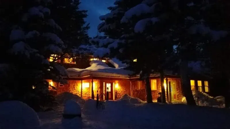 El chalet iluminado por la noche en invierno.