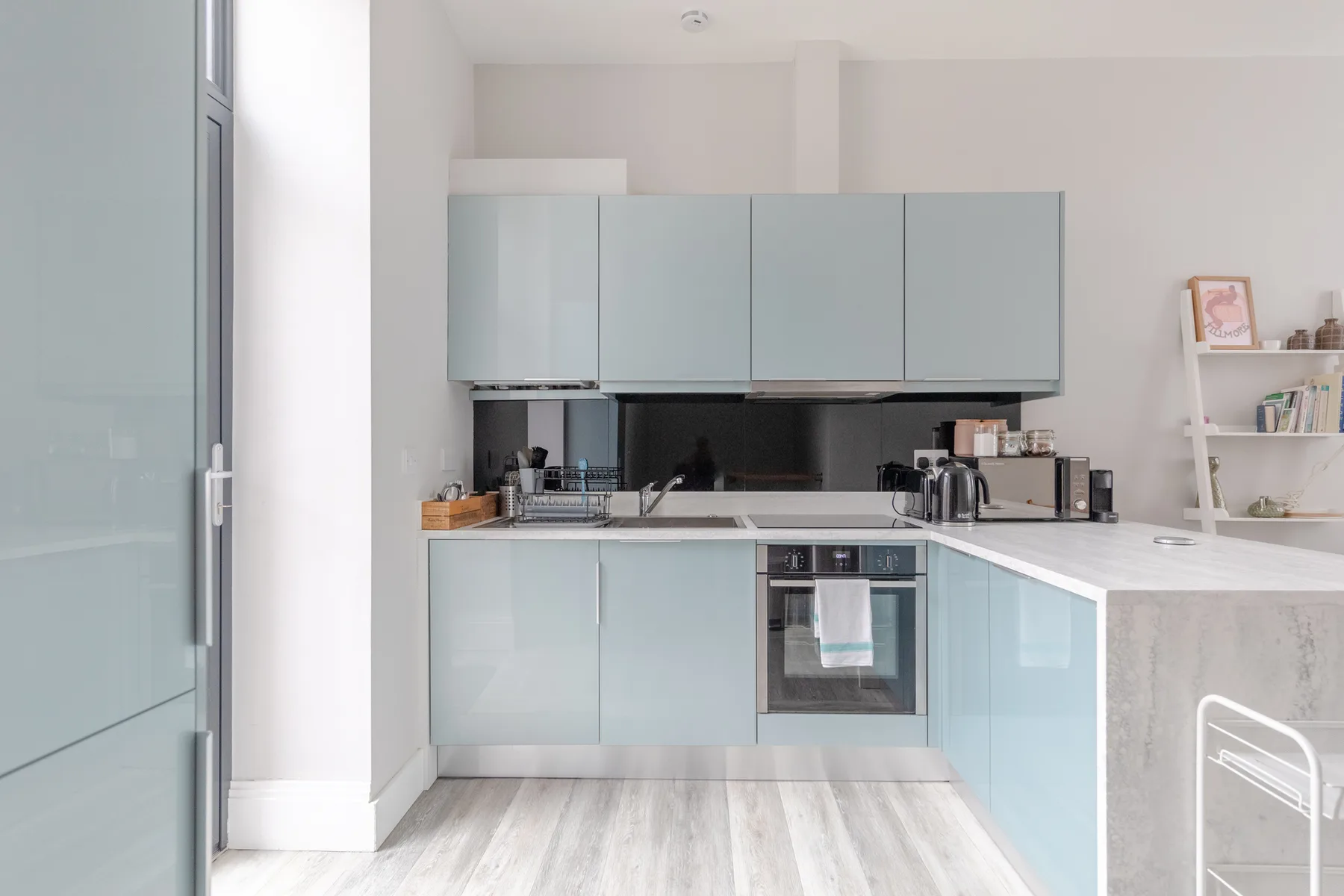 A bright kitchen with pale cabinets and a countertop.