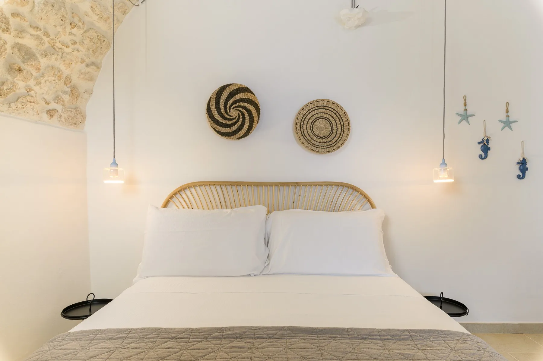Un dormitorio con una cama bien tendida y adornos tejidos en la pared.