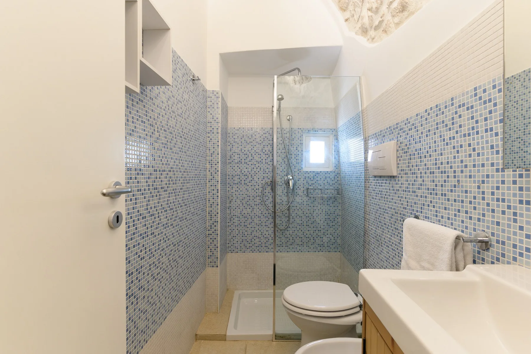 Un baño alicatado con ducha, inodoro y lavabo.