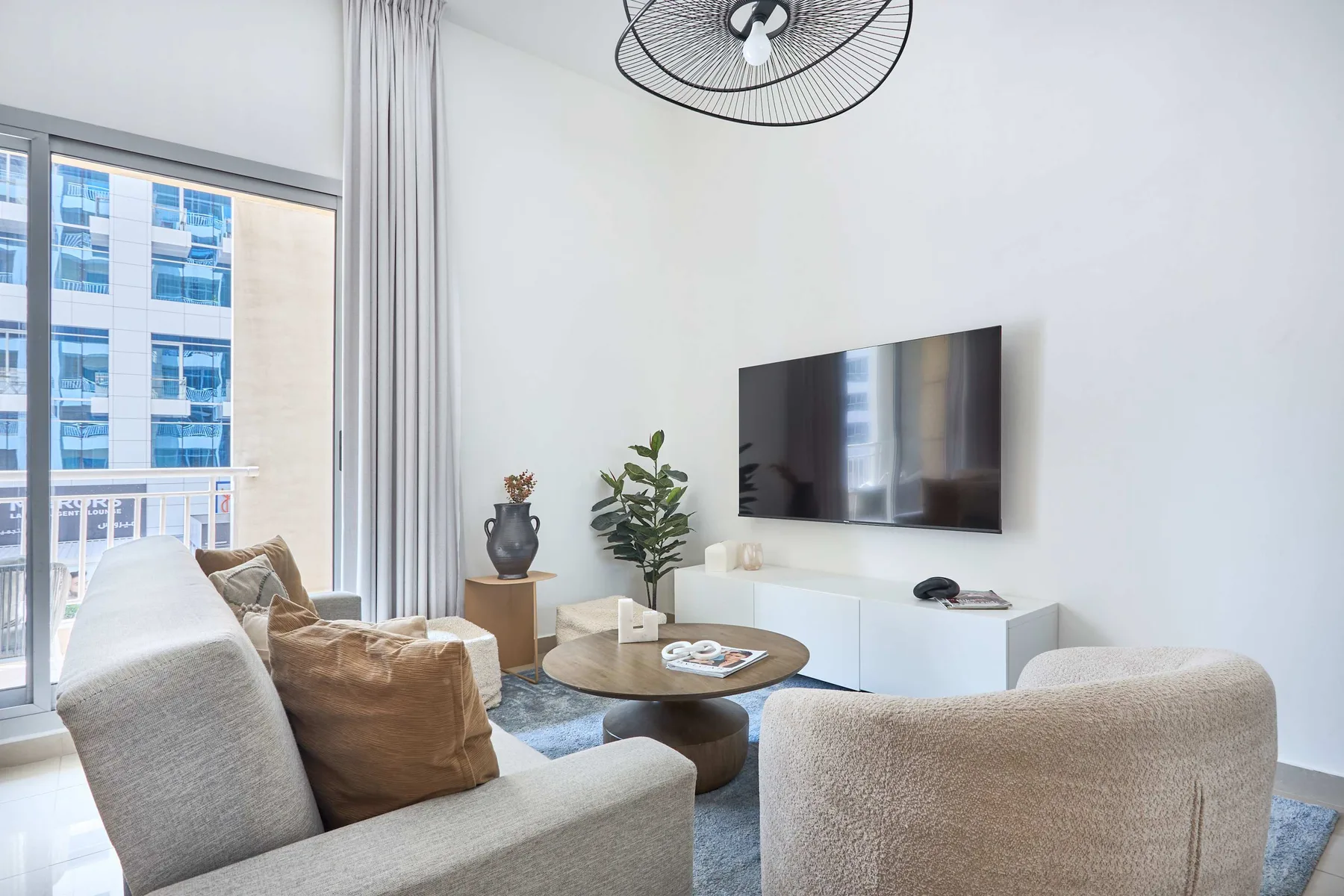 Una sala luminosa con asientos, una mesa de centro y un televisor.