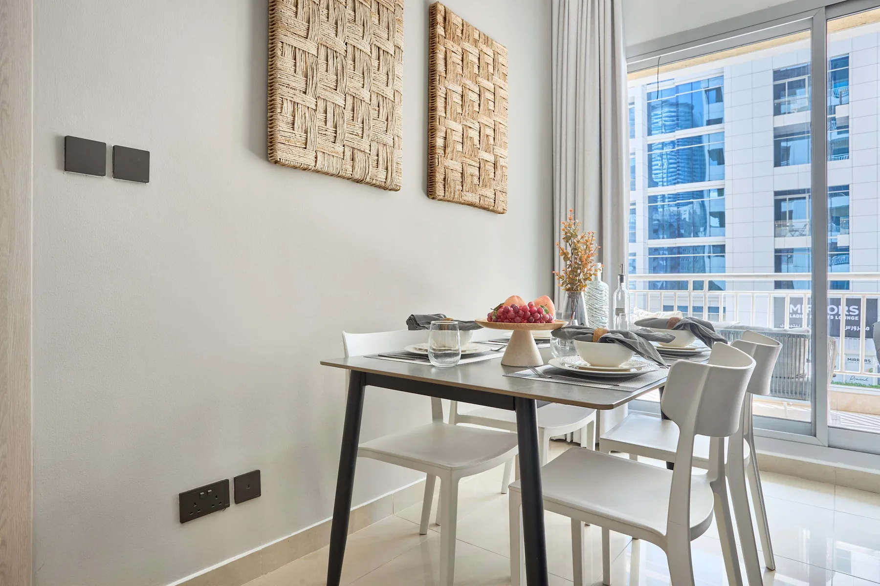 Un comedor con una mesa puesta junto a una ventana grande.