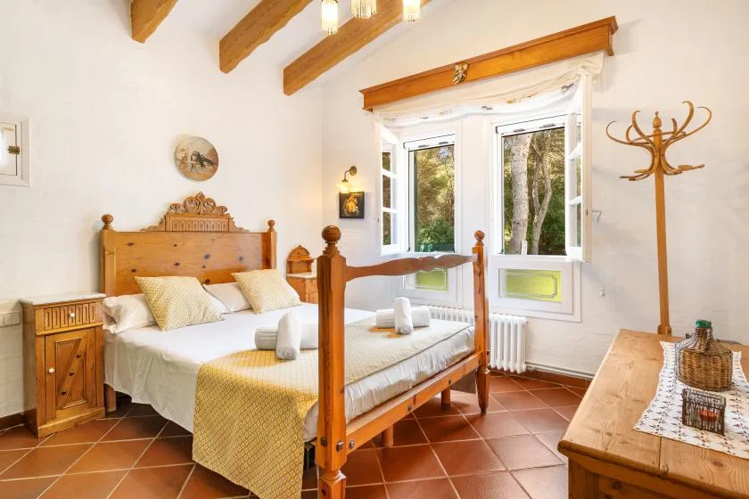 A bright bedroom with wooden beds and a large window.