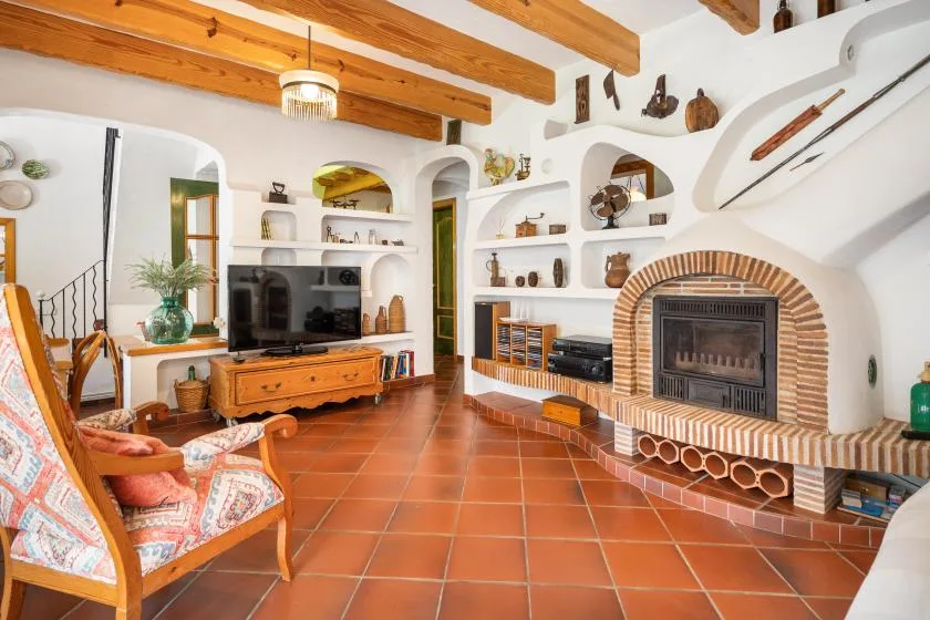 A living room with built-in shelving, a television, and a brick fireplace.