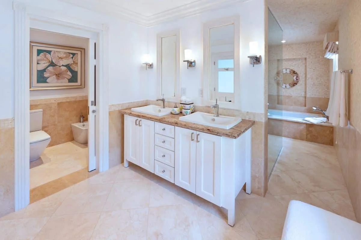Un baño luminoso con un tocador doble y una bañera.
