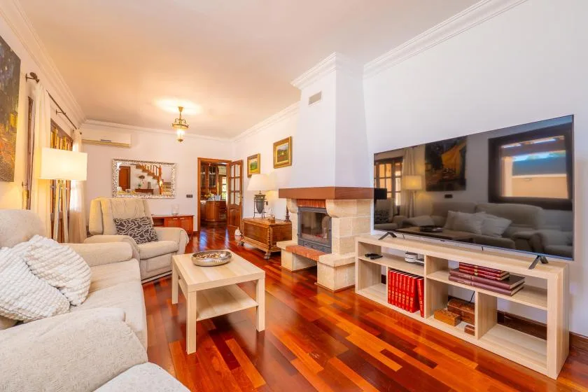 Una sala de estar con asientos, una mesa de centro y un televisor.