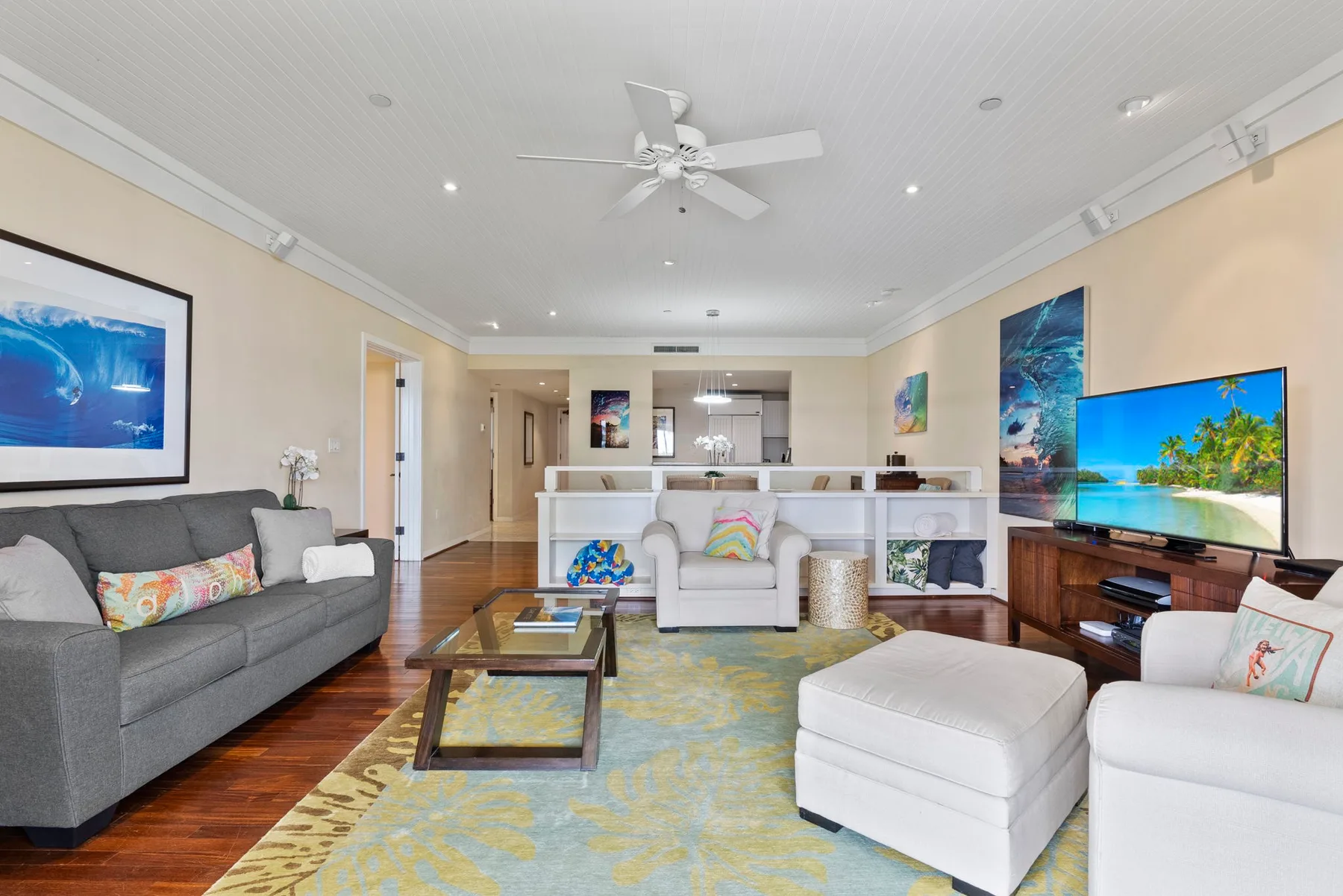A bright living room with seating, a television, and a coffee table.