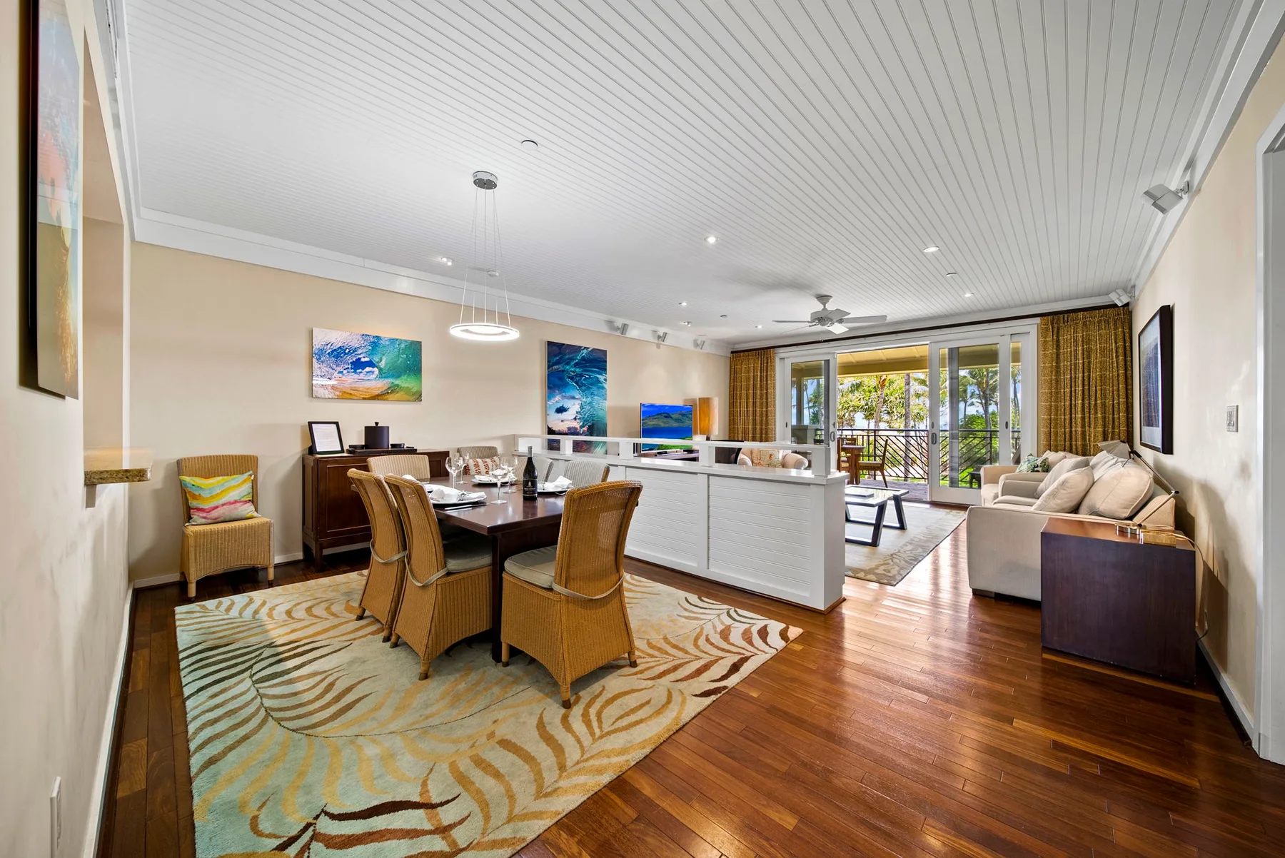 A bright open-plan living and dining room with seating around a dining table.