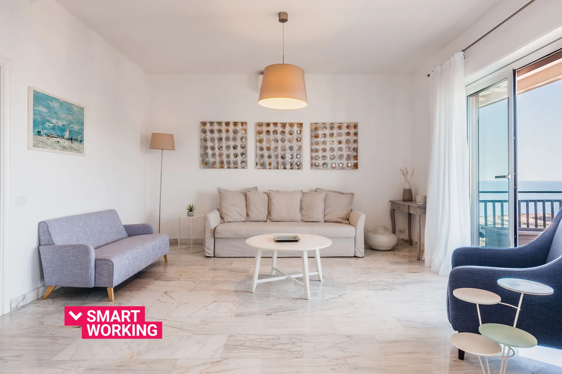 A bright living room with seating around a coffee table and a balcony door.